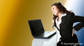 a person Carrolltown bending over a computer holding her back due to pain